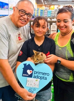 Valiente and his new family holding him at Petco