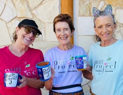 PuRR Project volunteers holding up the hand painted mugs