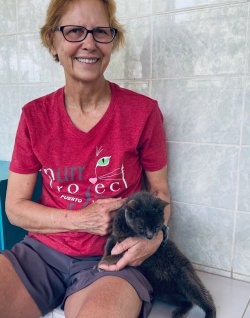 Dawn posing with her Virtually Adopted kitty Pearl, who is dark grey and sitting next to her