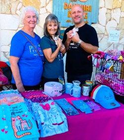 Volunteers posing with kittens at the PuRR Project table