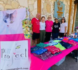 purr project volunteers posing at the table of t-shirts