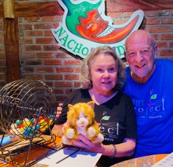 Bingo callers posing with the stuffed cat