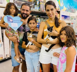 Family posing with the kittens they just adopted
